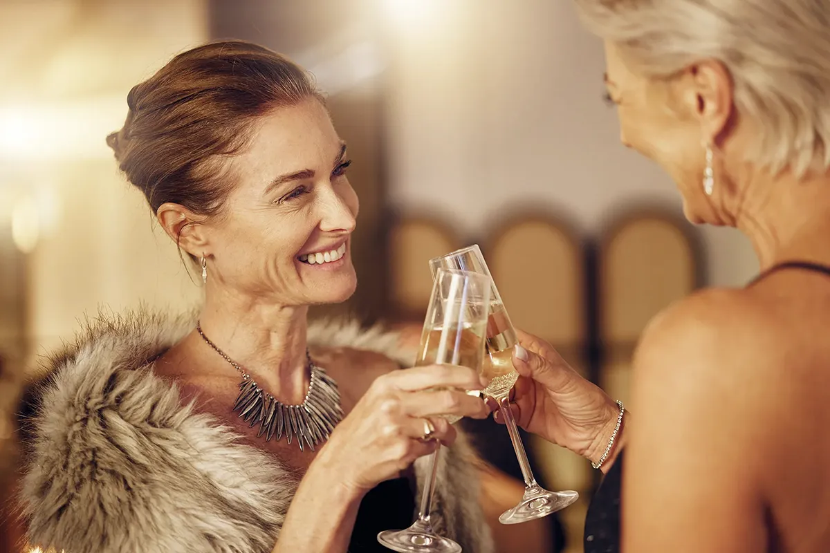 Dos mujeres elegantes brindan en una fiesta nocturna